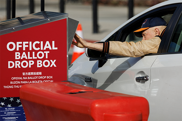 voter dropping his vote in a ballot box